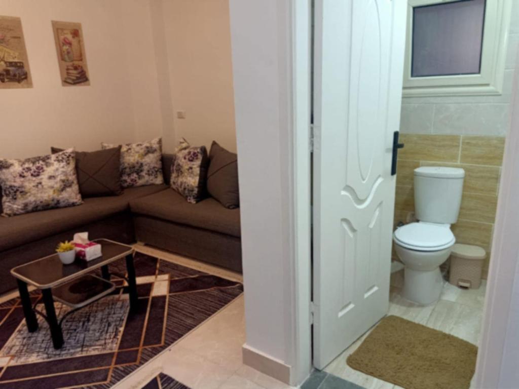 a living room with a couch and a toilet at شاليه بالساحل الشمالى قرية نيو كوست الكيلو 77 قبلى الطريق بشاطىء خاص in El Alamein