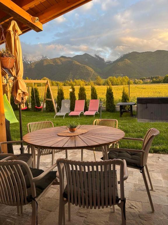 a patio with a table and chairs and a field at Mountain villa Aleksia- with JACUZZI in Razlog