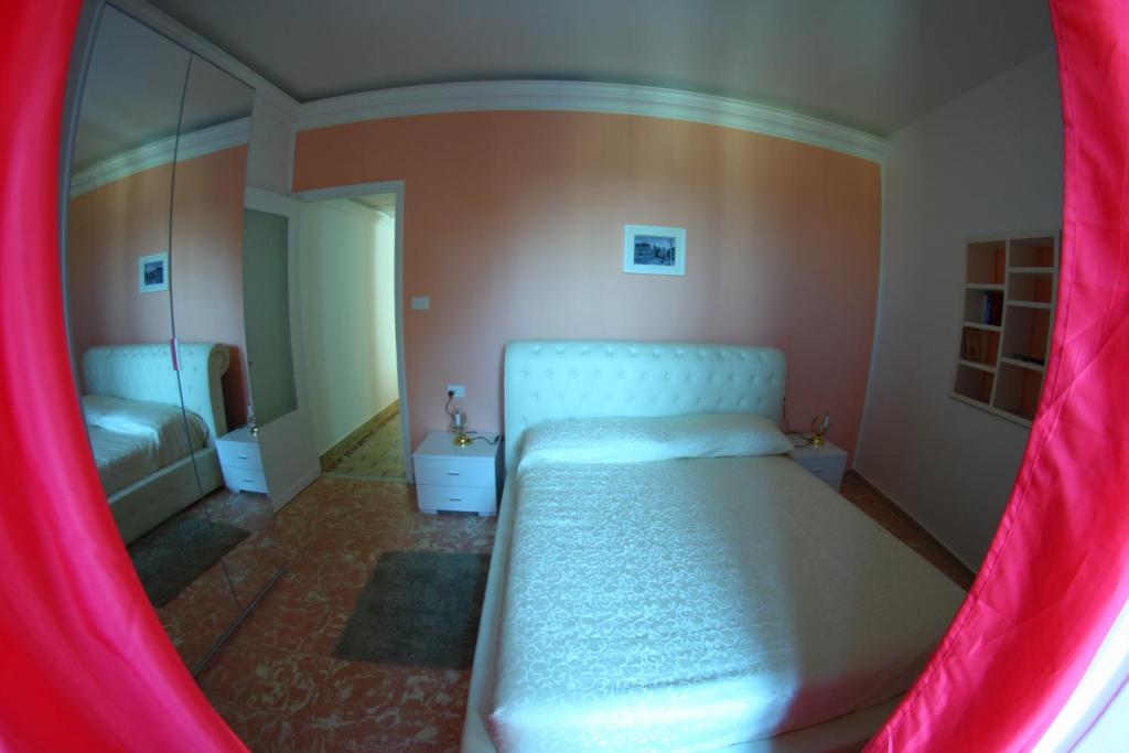 um quarto com uma cama com uma cortina rosa em Gualtiero Camere & Suite em Caltagirone