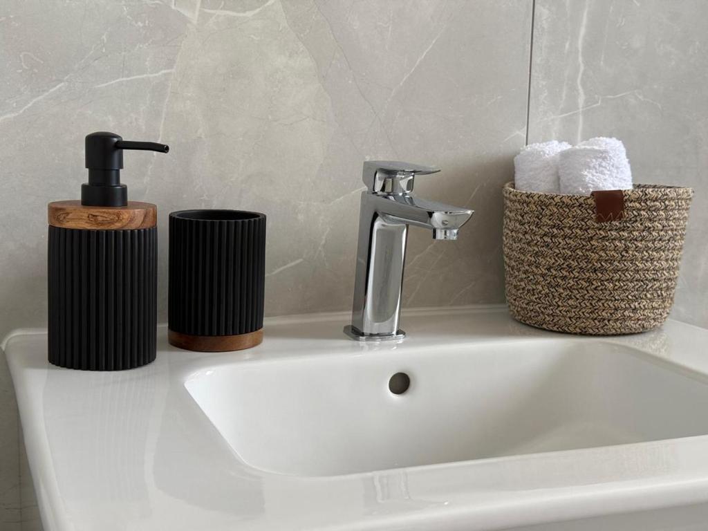 a bathroom sink with a faucet and towels on it at Chill and Stay-Luxury Studio in Kato Paphos in Paphos City
