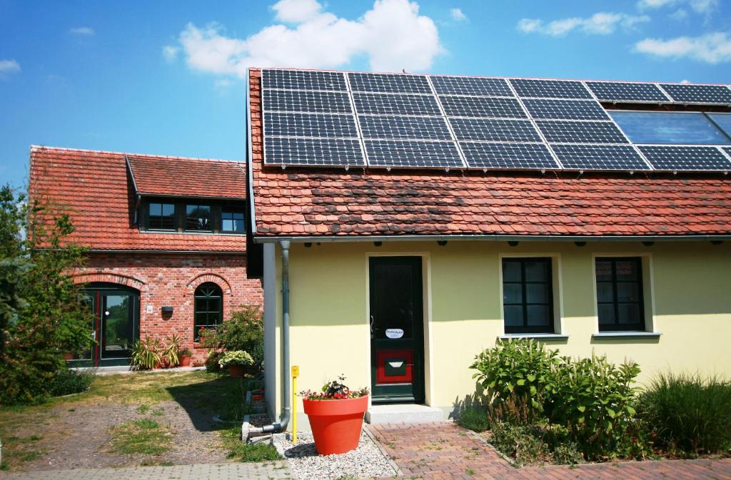 uma casa com painéis solares no telhado em Ferienwohnung am Hohennauener See em Wassersuppe