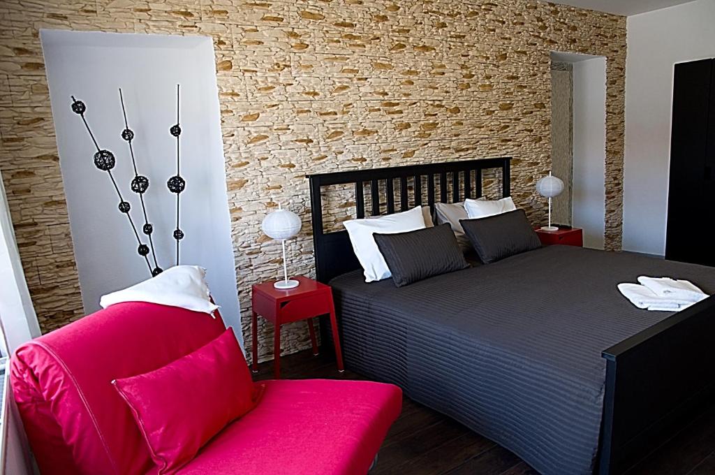 a bedroom with a bed and a red couch at Apartments Centrum in Rožnov pod Radhoštěm