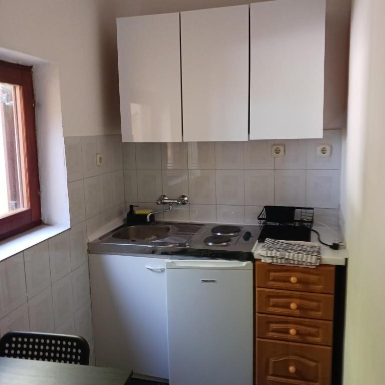 a small kitchen with a sink and a stove at Apartments Elena & Damir in Vis