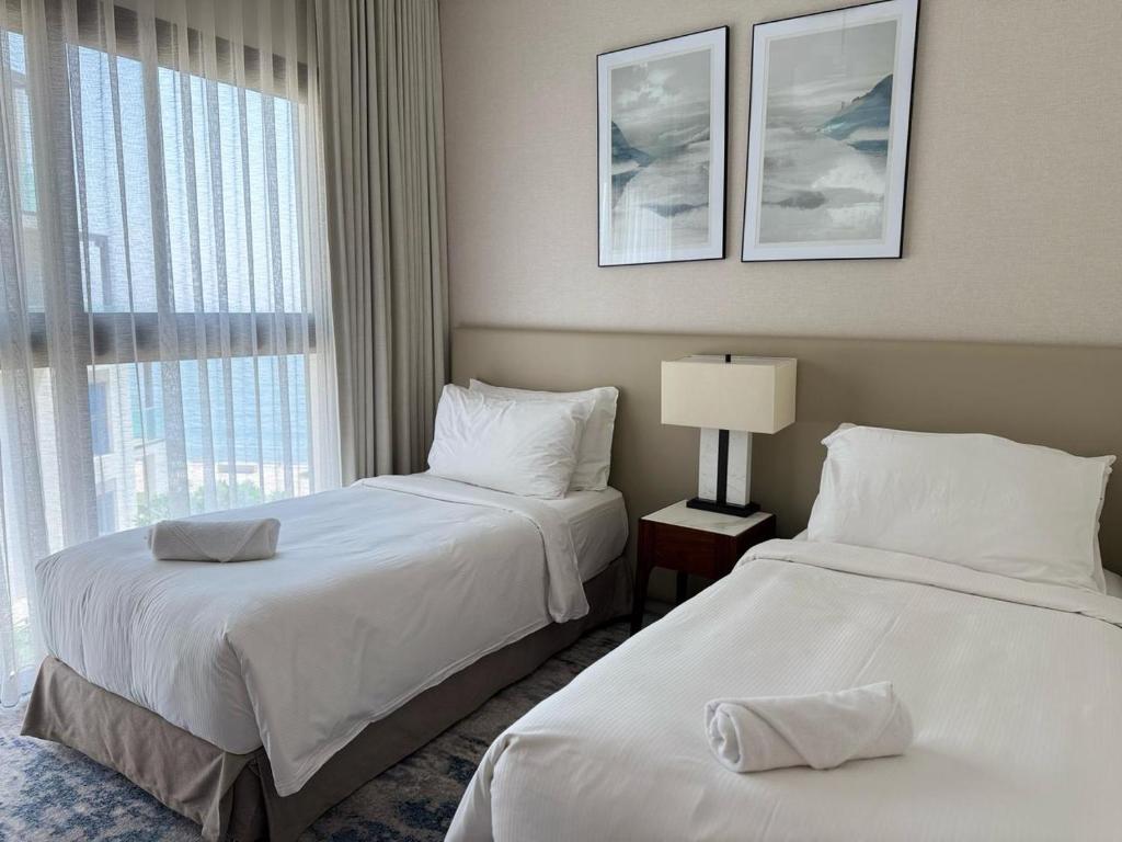 a hotel room with two beds and a window at Address Beach Resort Fujairah Apartment by Blue World - 4 in Fujairah