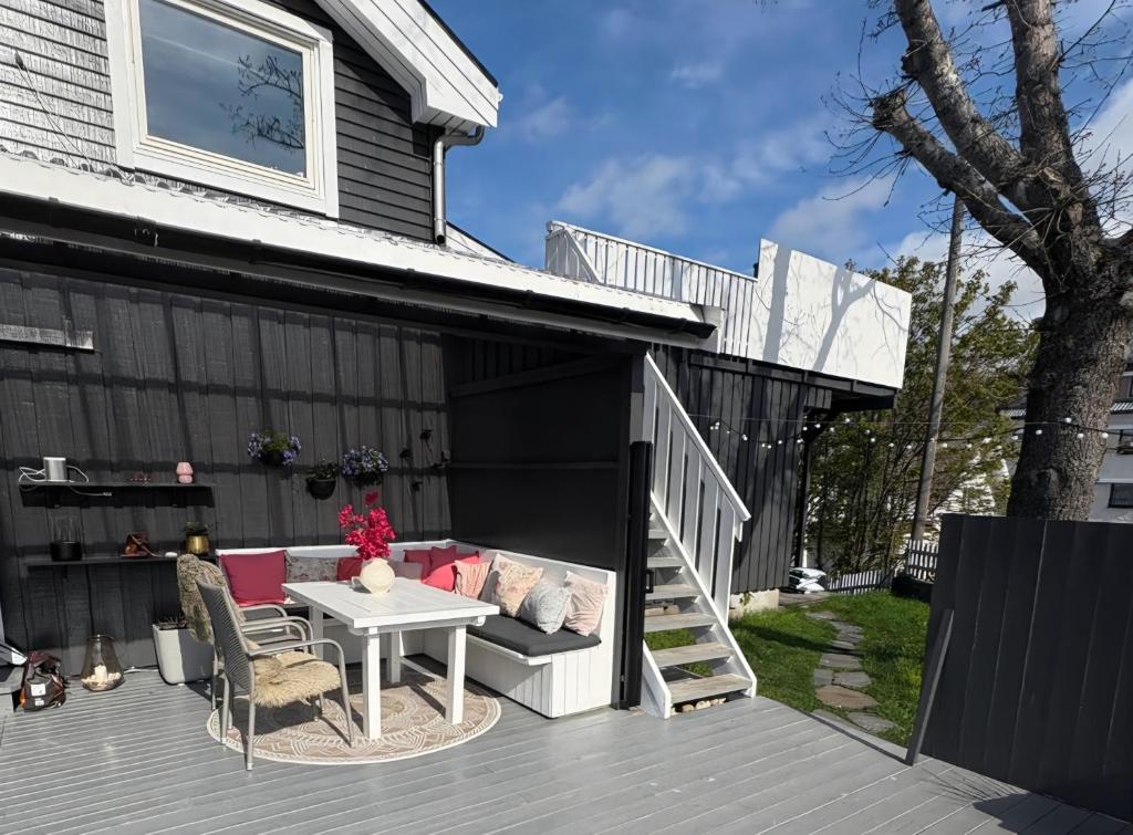 a backyard deck with a white table and chairs at Flott beliggenhet svært sentralt i sentrum in Svolvær