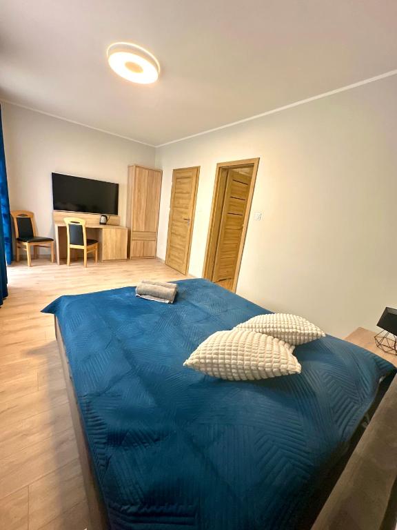 a bedroom with a bed with a blue blanket at Willa Dominik 2 in Jastarnia