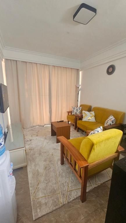 a living room with two couches and a yellow couch at Padmore Residences - B1506 in Nairobi
