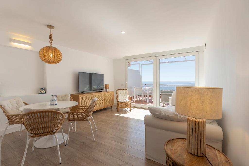 a living room with a couch and a table at Atico espacioso con vistas panorámicas in Calahonda