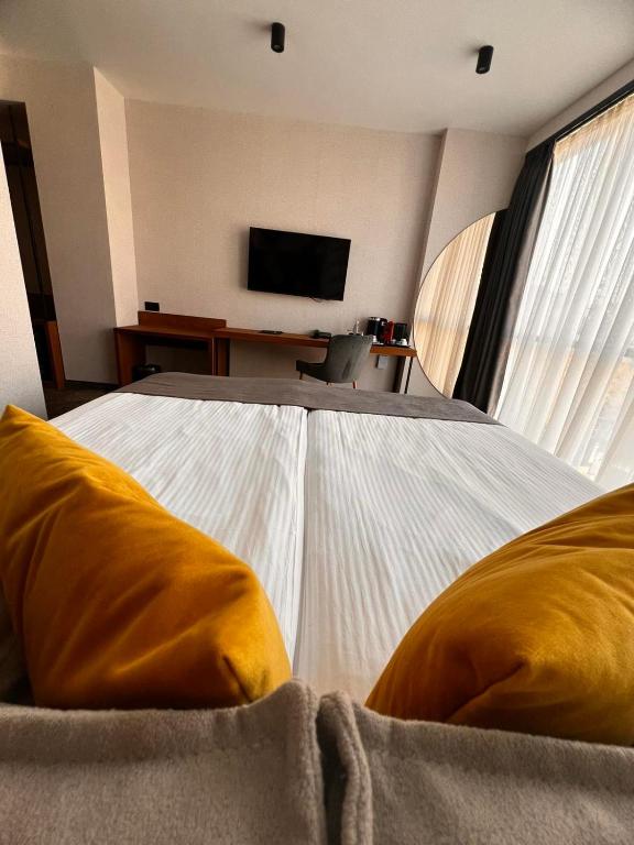 a bedroom with a large bed with a tv on the wall at MM Boutique Hotel in Burgas