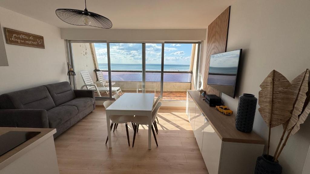 un salon avec un canapé et une table dans l'établissement Appartement Marina FACE MER, à Saint-Jean-de-Monts