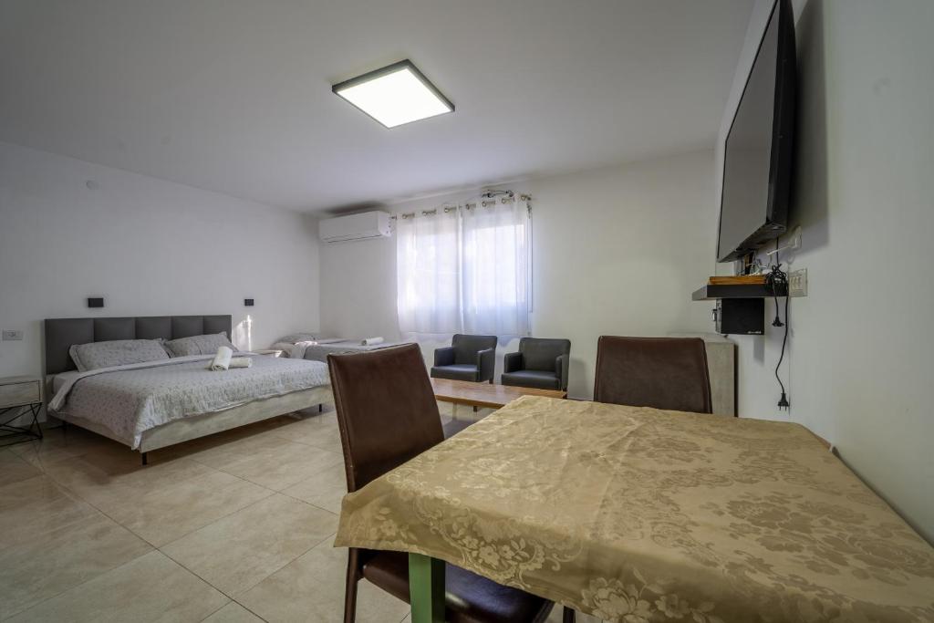ein Wohnzimmer mit einem Bett und einem Tisch mit Stühlen in der Unterkunft אדום 179, דירות נופש in Eilat