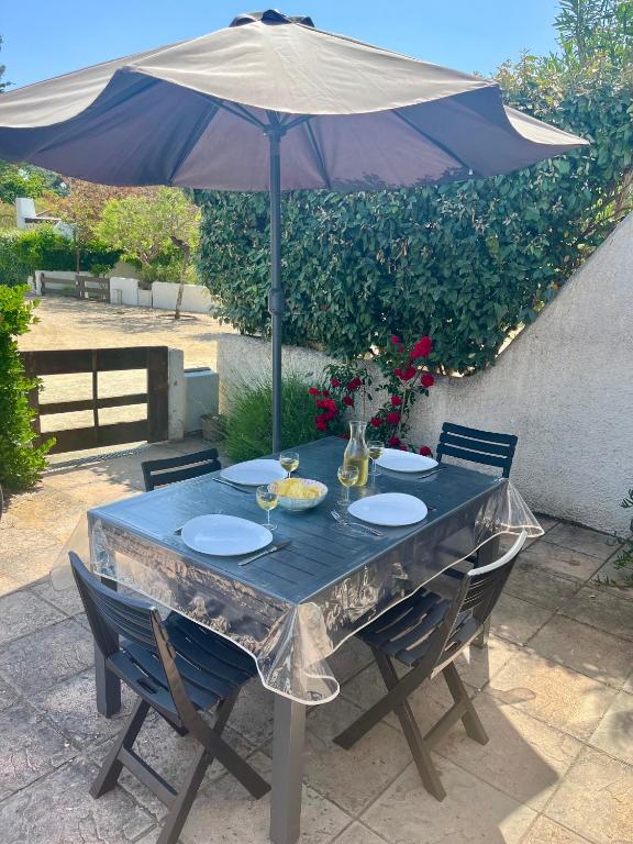 une table bleue avec un parasol et quelques chaises dans l'établissement Camelia, à Saint-Jean-de-Monts