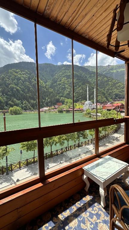 a room with a large window with a view of the water at Dunya Residence in Uzungöl