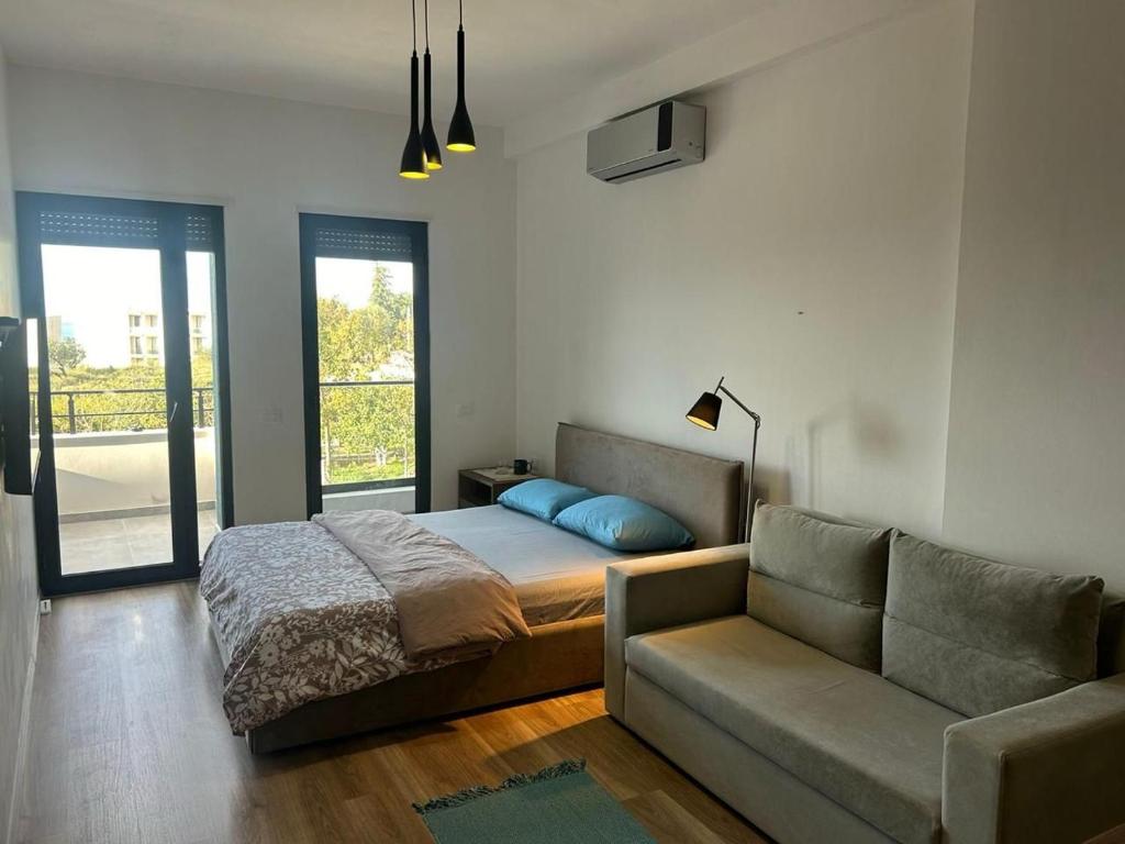a bedroom with a bed and a couch at Katoria Bridge Apartment in Vlorë