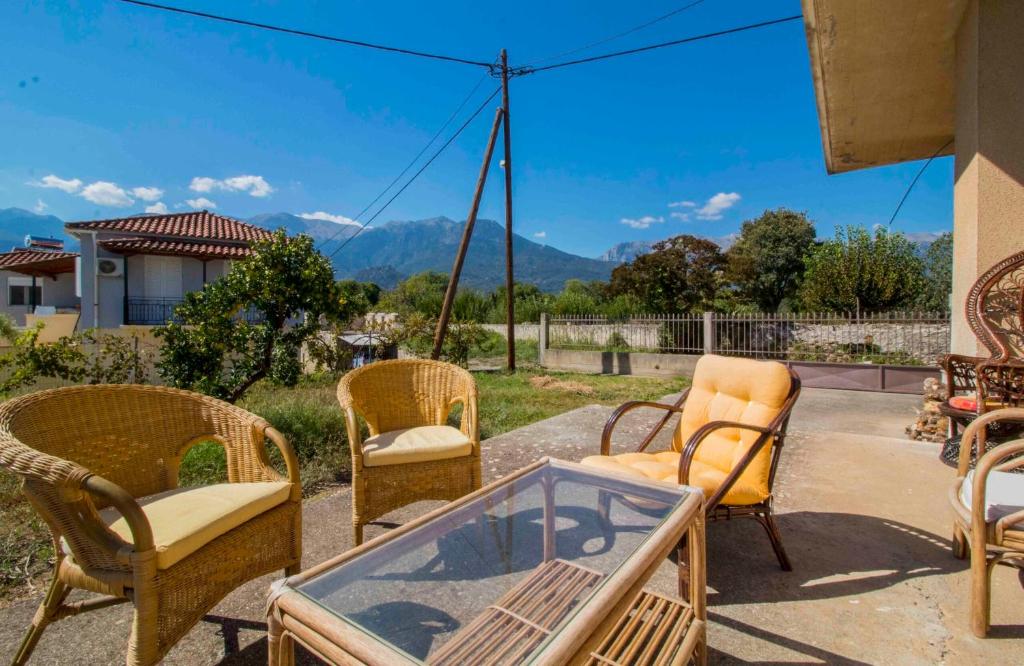 a group of chairs and a glass table on a patio at ΕΥΡΥΧΩΡΟ ΣΠΤΙ στη Μαγουλα in Magoúla
