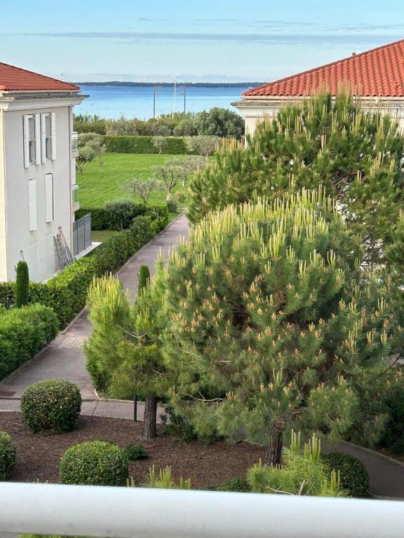 - une vue sur un jardin arboré et un bâtiment dans l'établissement T2 dans résidence standing Juan Flore dernier étage avec terrasse vue mer, à Antibes
