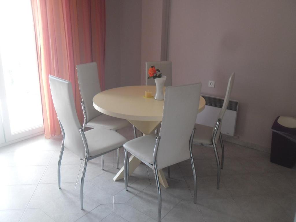 a dining room table with white chairs and a table at Apartments Dunja Piric in Lopar