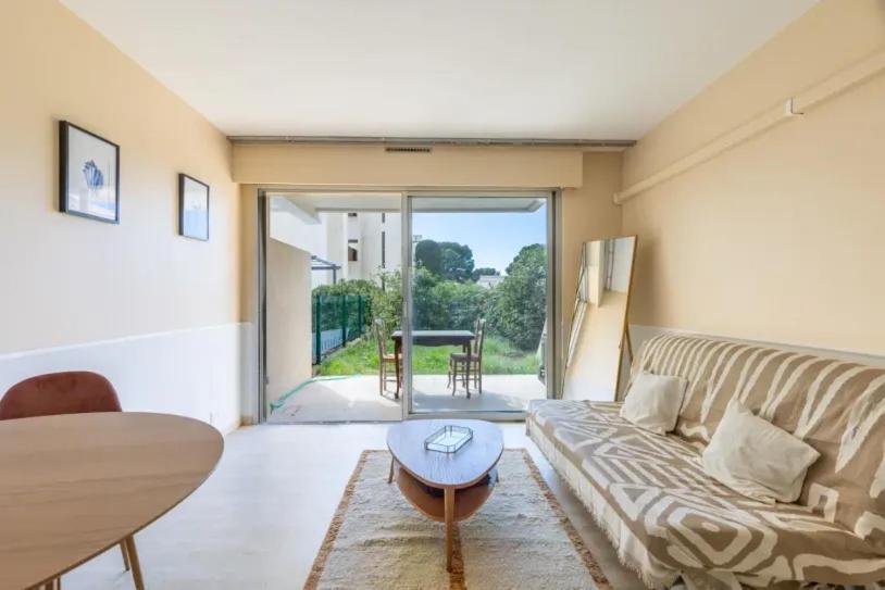 un salon avec un canapé et une table dans l'établissement Studio rénové à Bandol avec jardin privé - 5 min de la plage, à Bandol