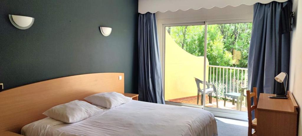 Postel nebo postele na pokoji v ubytování Hôtel Sous l'Olivier