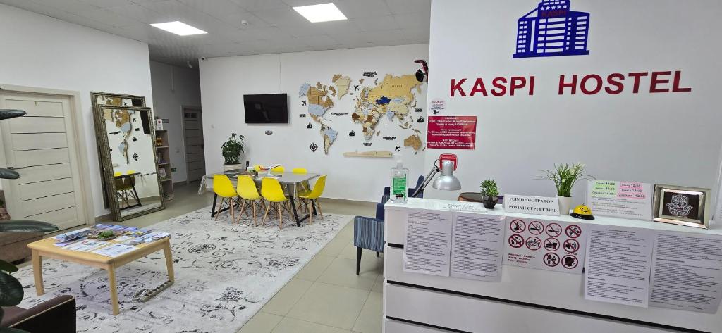 a room with a kitchen and a table with yellow chairs at KASPI HOSTEl in Aktau