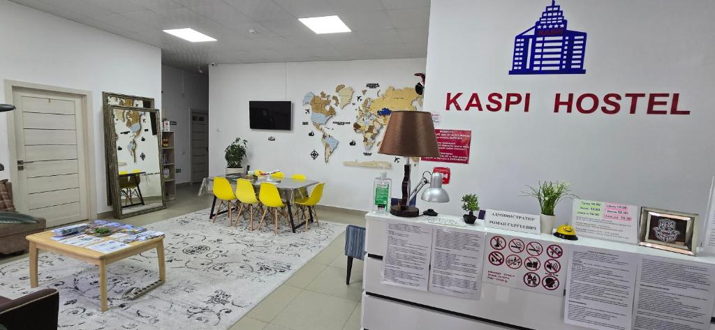 a room with a table and yellow chairs in a room at KASPI HOSTEl in Aktau