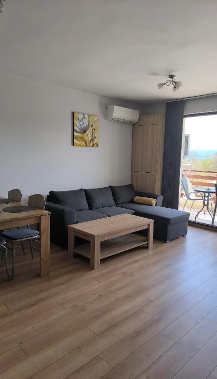 a living room with a blue couch and a table at Апартамент Славяна in Velingrad