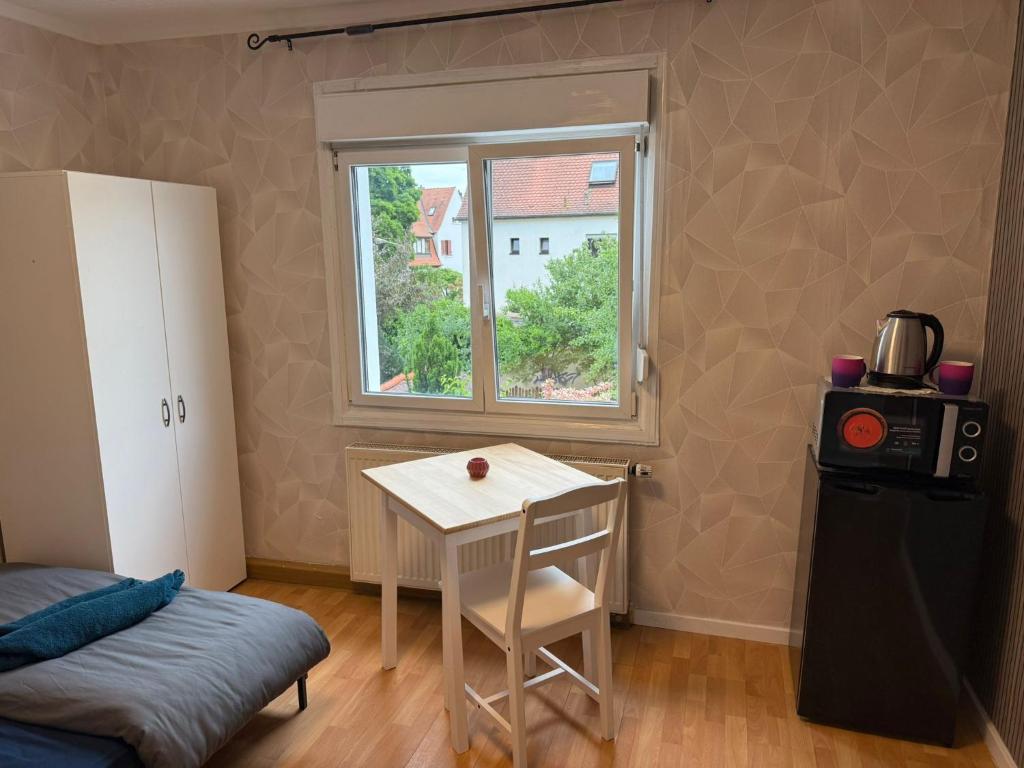 Camera piccola con tavolo e finestra di Einzelzimmer mit Gemeinschaftsbad ohne Küche a Norimberga