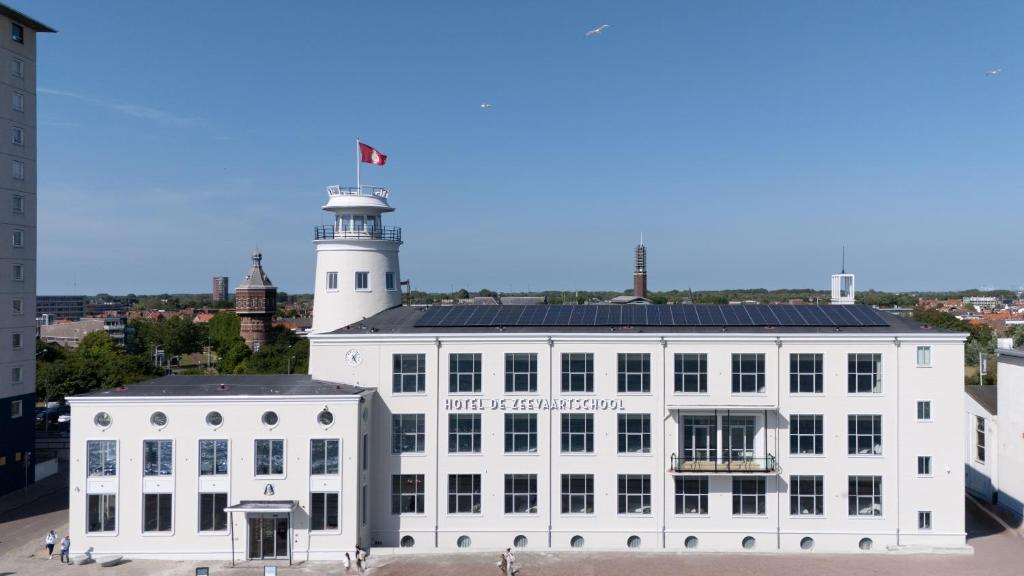un edificio blanco con un faro encima en Hotel De Zeevaartschool, en Vlissingen