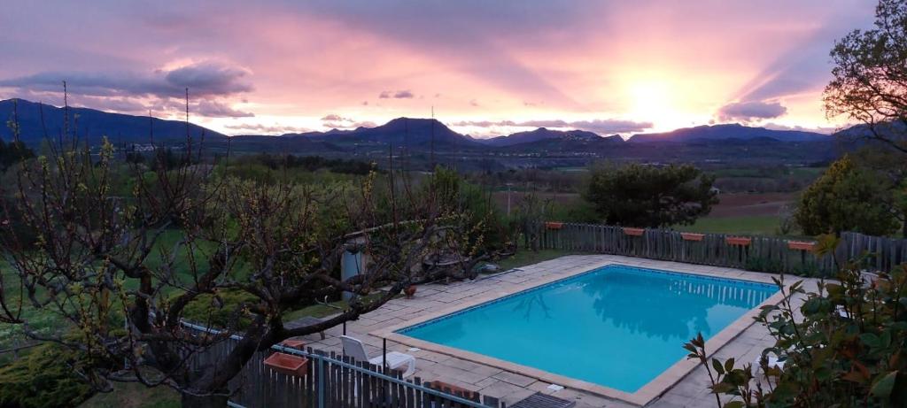 une piscine avec un coucher de soleil en arrière-plan dans l'établissement Le Jas des Sagnières - Gite de Charme en Haute Provence -, à Sigoyer