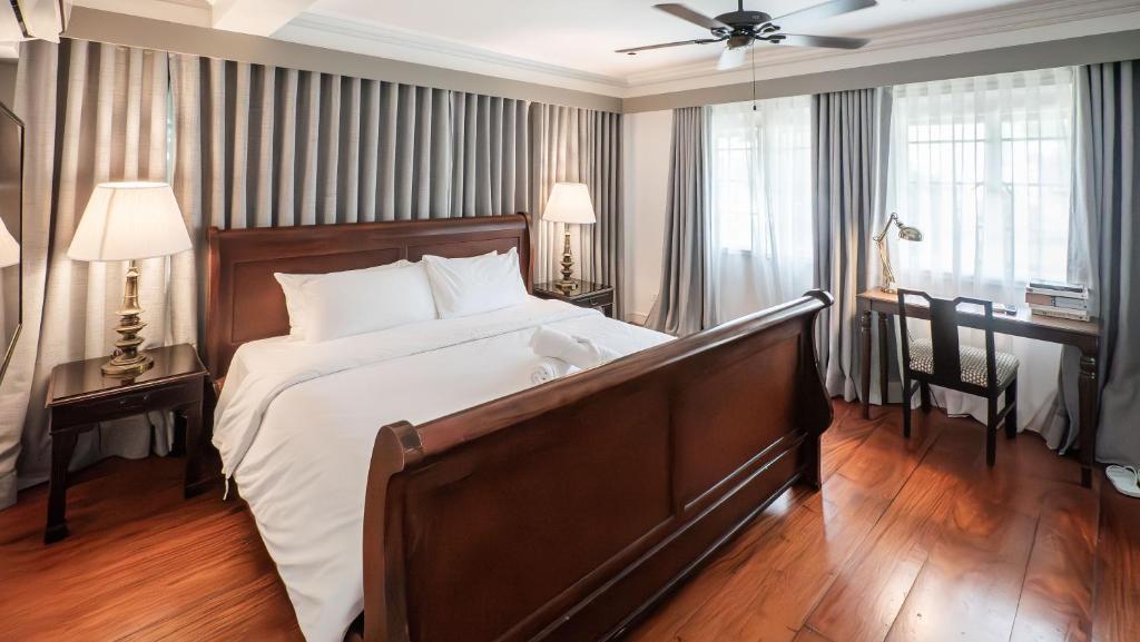 a large bedroom with a large bed and a desk at MiraNamin Nest LIRYO and LANTANA Residence in Unique Historic Home - Garden, Rooftop, Private Kitchen in Manila