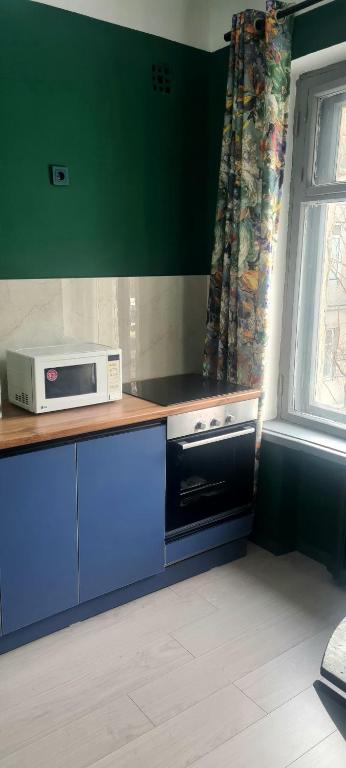 a kitchen with a microwave on a counter with a window at Opera in Bishkek