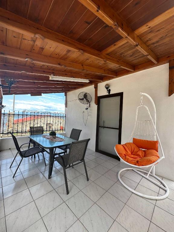 a patio with a swing and a table and chairs at Penelope House in Skala Kallirachis