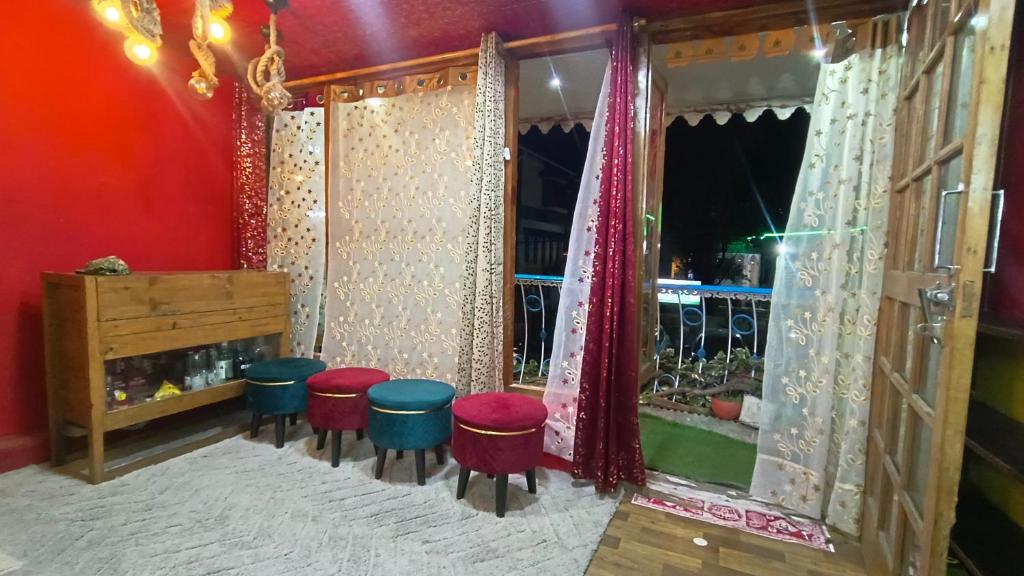 a room with a row of stools in front of a window at The Money Plant House in Nainital