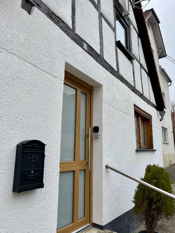 a white building with a wooden door and a window at Stadtperle Apartment in Neresheim