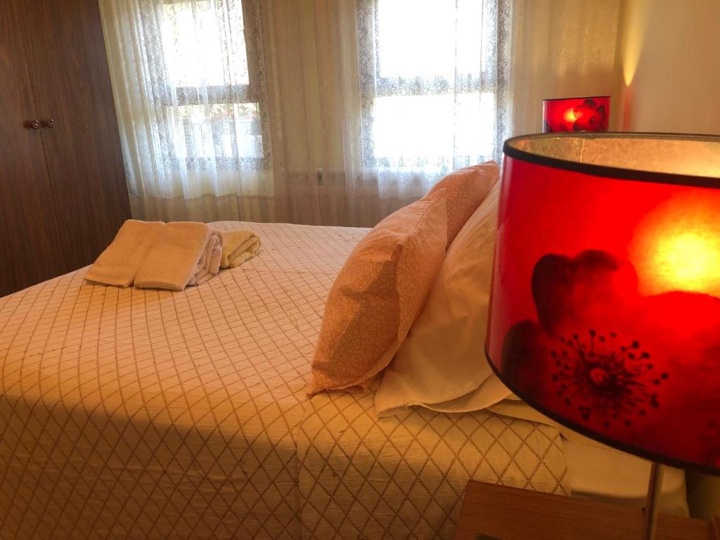 Un dormitorio con una cama con una lámpara roja. en Apartamentos MyM, en Jaca
