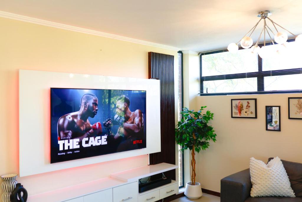 a living room with a flat screen tv at Golf Estate Living 1BR Apartment in Jackal Creek in Roodepoort