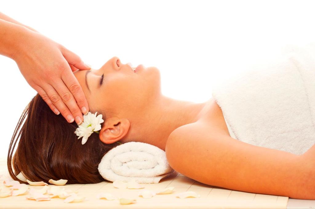 a woman getting a massage from a therapist at Troia Design Hotel in Troia
