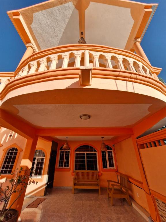 ein Gebäude mit einem Balkon mit einer Bank darauf in der Unterkunft Casa para 18 personas con AC, cocina y a 10 min de la Playa in Playa del Carmen