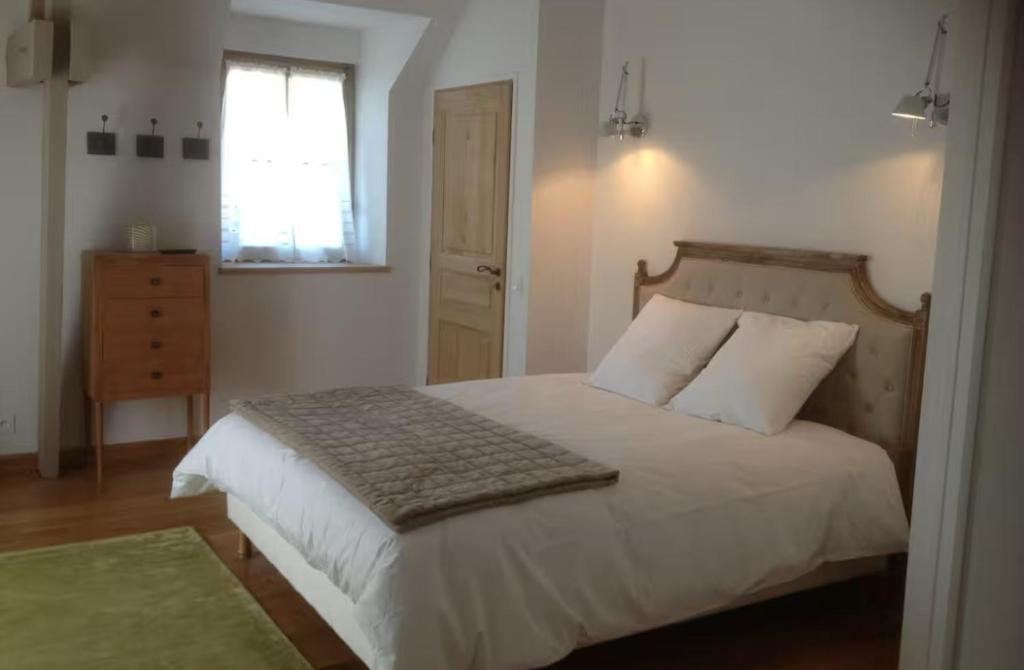 une chambre avec un lit blanc et une fenêtre dans l'établissement Le hameau des vignes, à Saint-Julien-de-Chédon