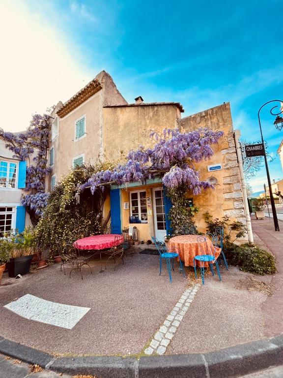 une maison avec une table et des fleurs violettes dessus dans l'établissement La Sarrasine, à Villes-sur-Auzon