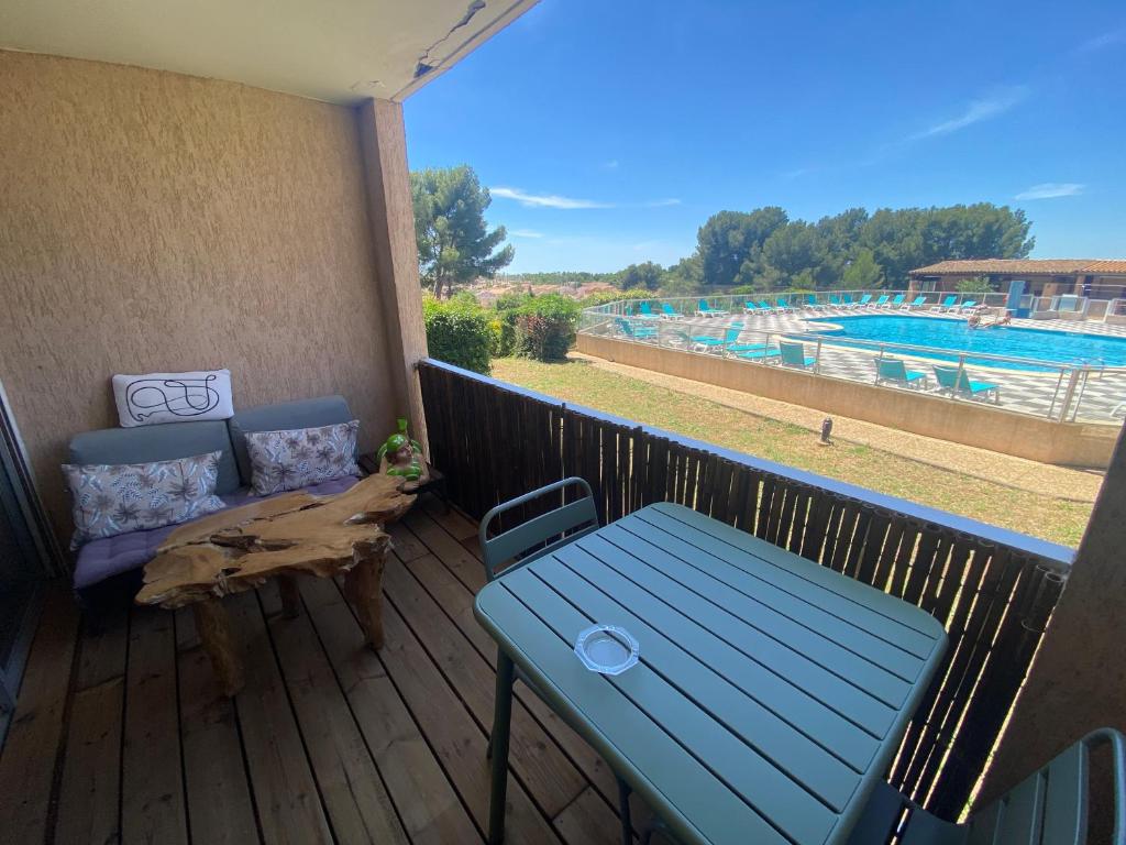 a deck with a bench and a table and a pool at Studio zen piscine in Balaruc-les-Bains