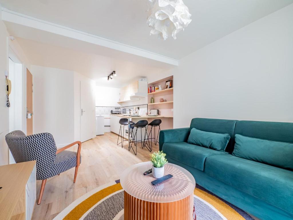 un salon avec un canapé vert et une table dans l'établissement OIQIA • Advena • Canson, à Annonay