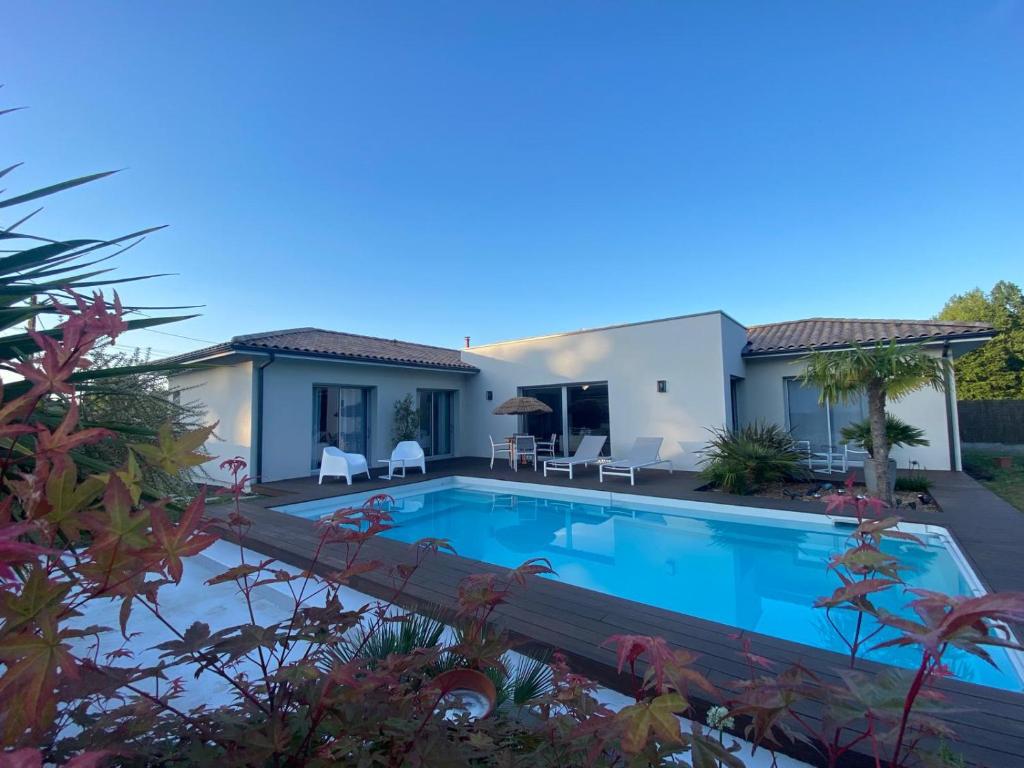 a villa with a swimming pool in front of a house at La Musardise Guest House in Berson