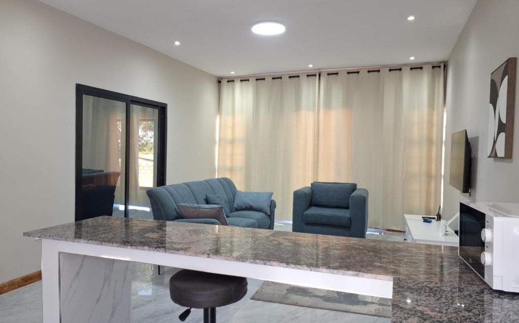 un salon avec deux chaises bleues et une table dans l'établissement Lowin Suites-One-Bed Apartments, à Lusaka