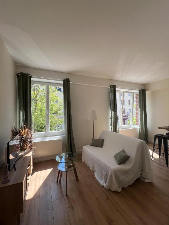 une chambre avec un lit, une table et des fenêtres dans l'établissement Studio au cœur d Amiens, à Amiens