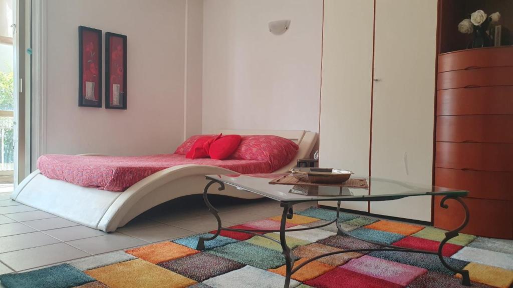 - un salon avec un lit et une table en verre dans l'établissement CANNES Un pied dans l'eau, Un pied en ville, à Cannes