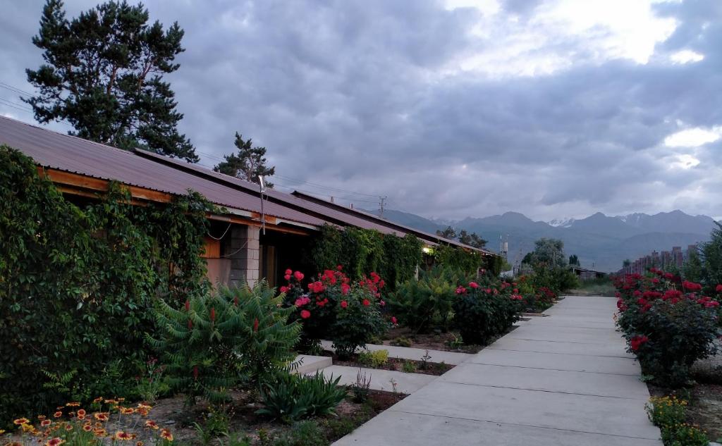 a walkway in front of a building with flowers at Пансионат Абрикос in Dolinka