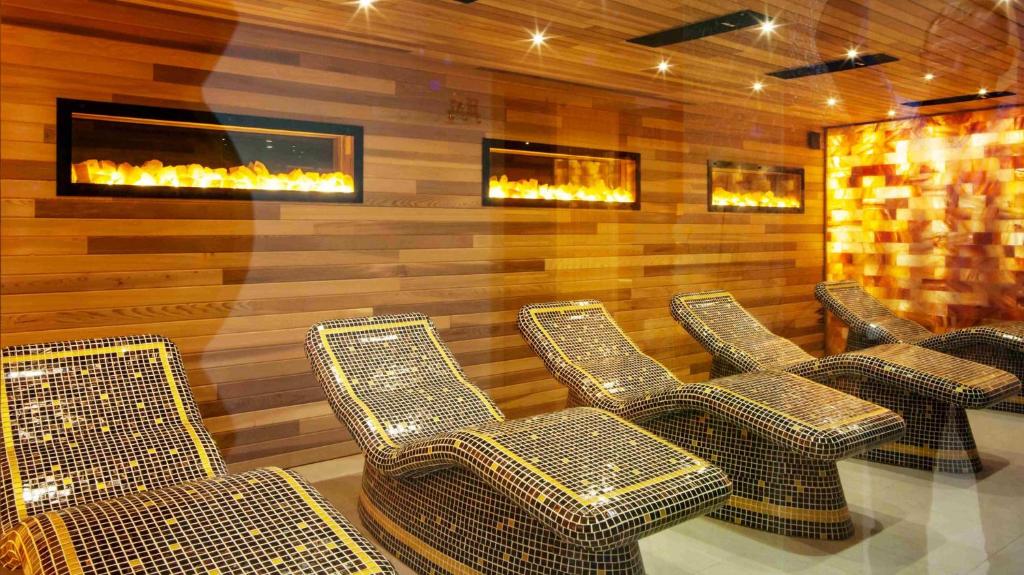 a row of chairs in a room with a fireplace at FeWo Allgäu Natur Spa in Wiggensbach