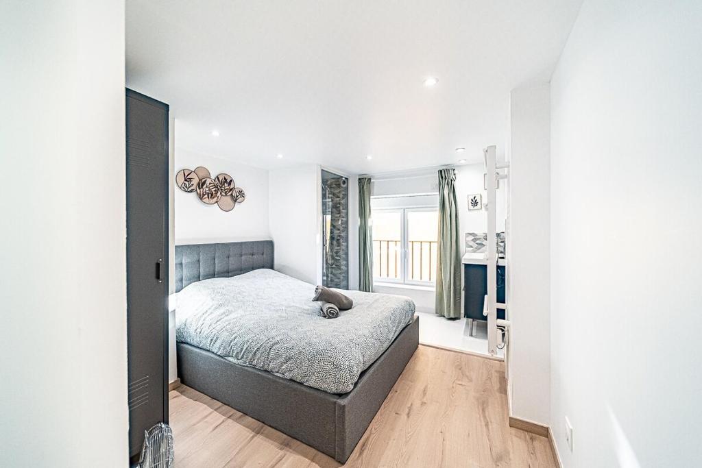 Una habitación blanca con una cama y una ventana en Cocon moderne Émile Zola, en Villeurbanne