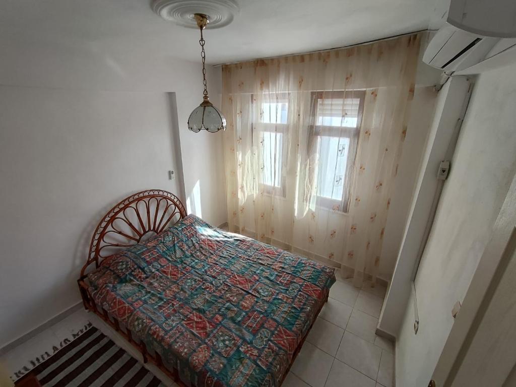 a small bedroom with a bed and a window at Huzurlu Triplex Villa in Bozyazı